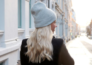 Kvinne med blondt hår og lue i vinterlys – typisk situasjon som kan gi statisk hår.