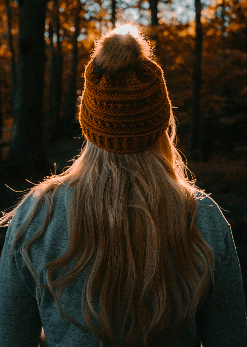 Langhåret person med lue i kald høstluft – typisk sesong for statisk hår og tørrhet.
