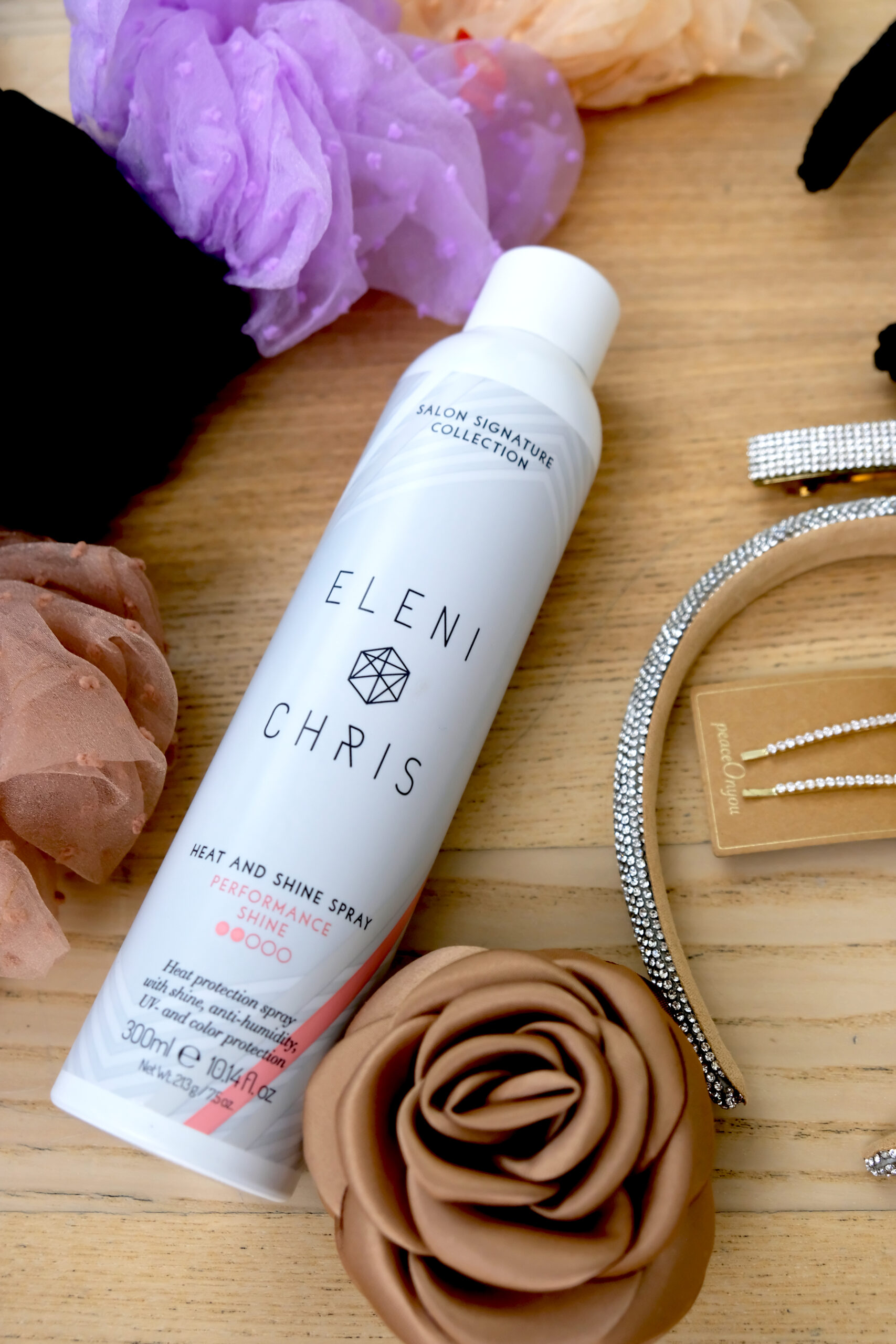 Eleni & Chris Heat and Shine Spray sammen med hårtilbehør på bord