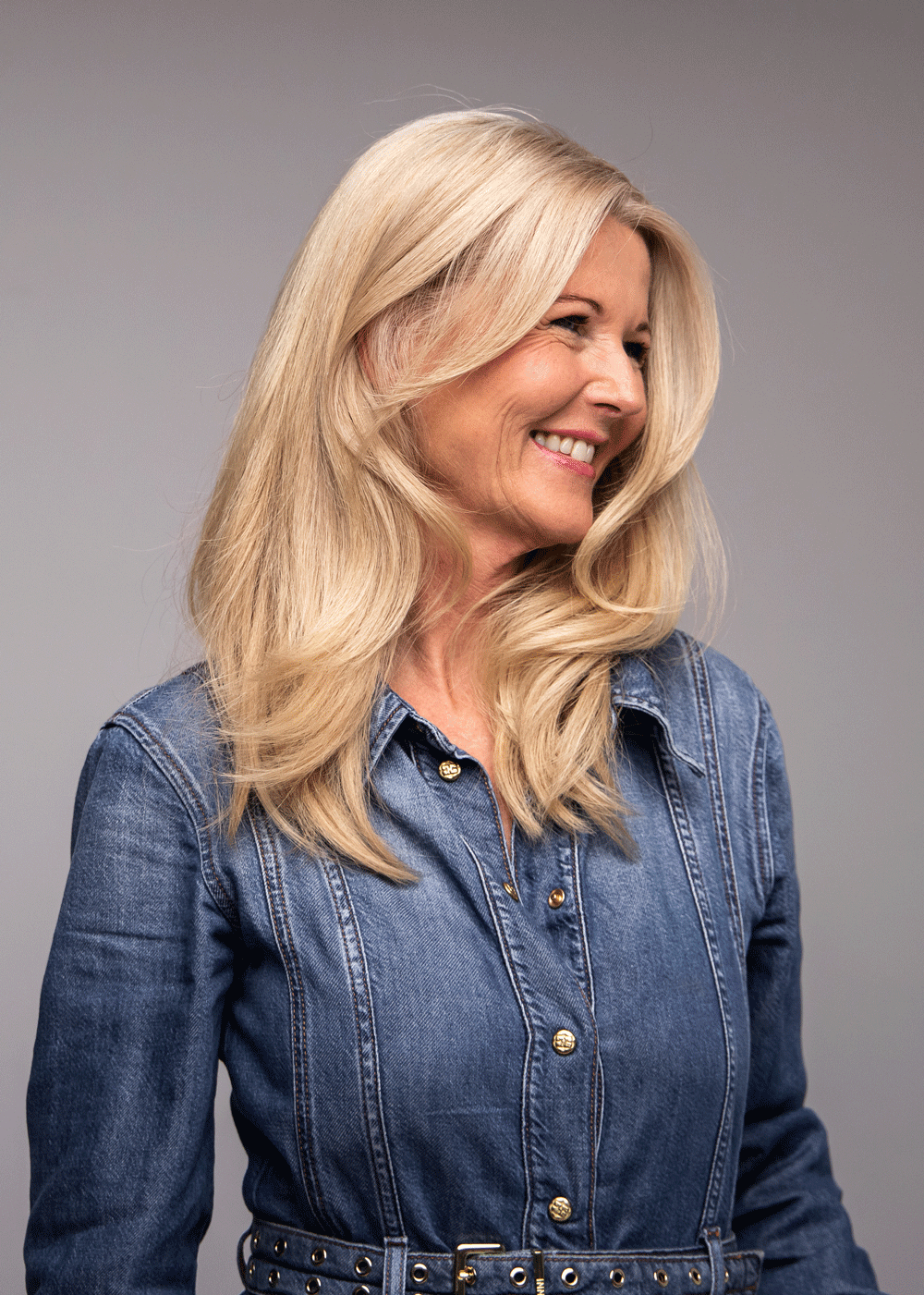 Kvinne med blowout-hår sett fra siden – glansfullt og voluminøst hår, Nikita Hair