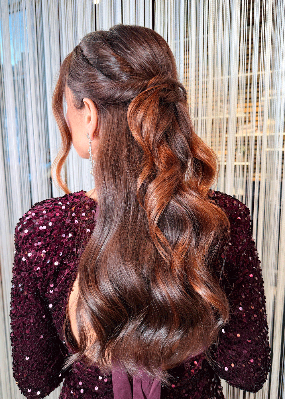 Halvt opp-frisyre med tvinnede seksjoner og myke bølger i langt, brunt hår