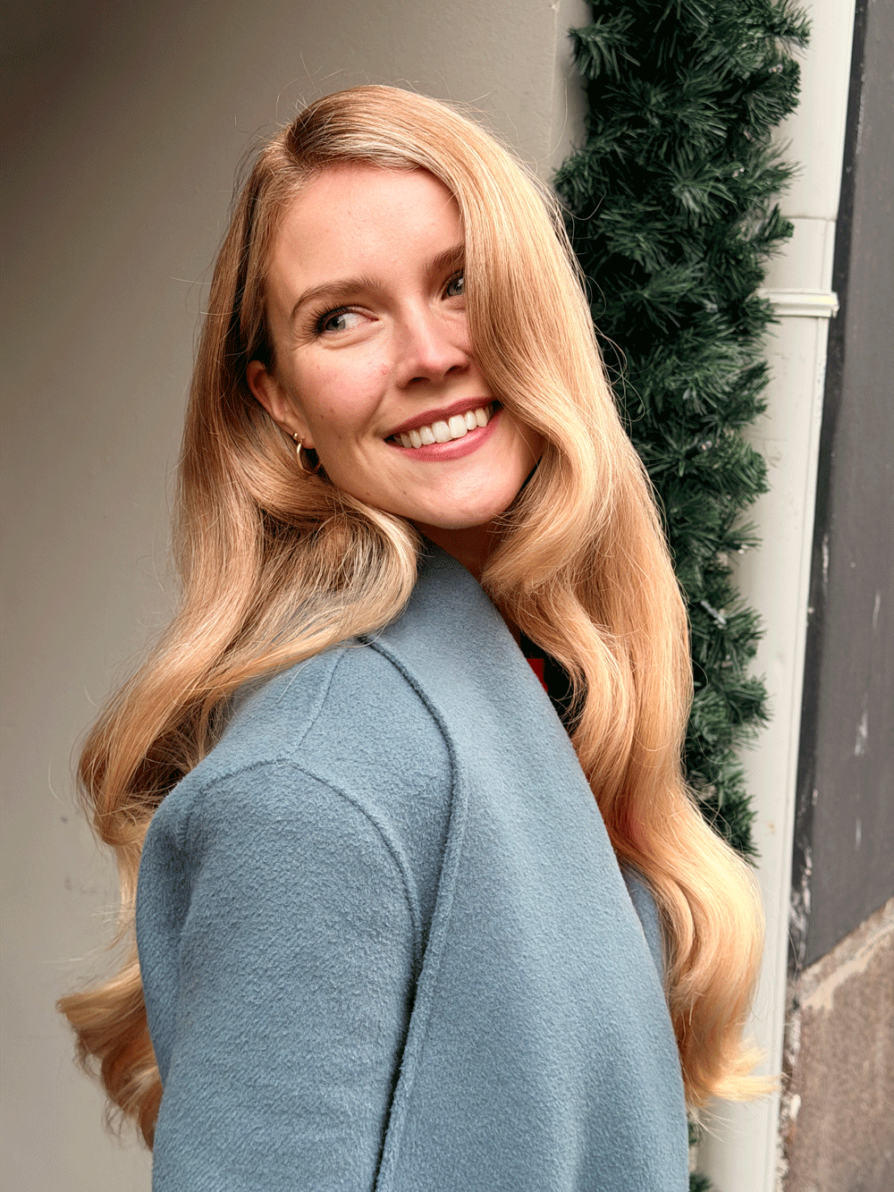 Langt blondt hår i store, glansfulle Hollywood-bølger med sideskille