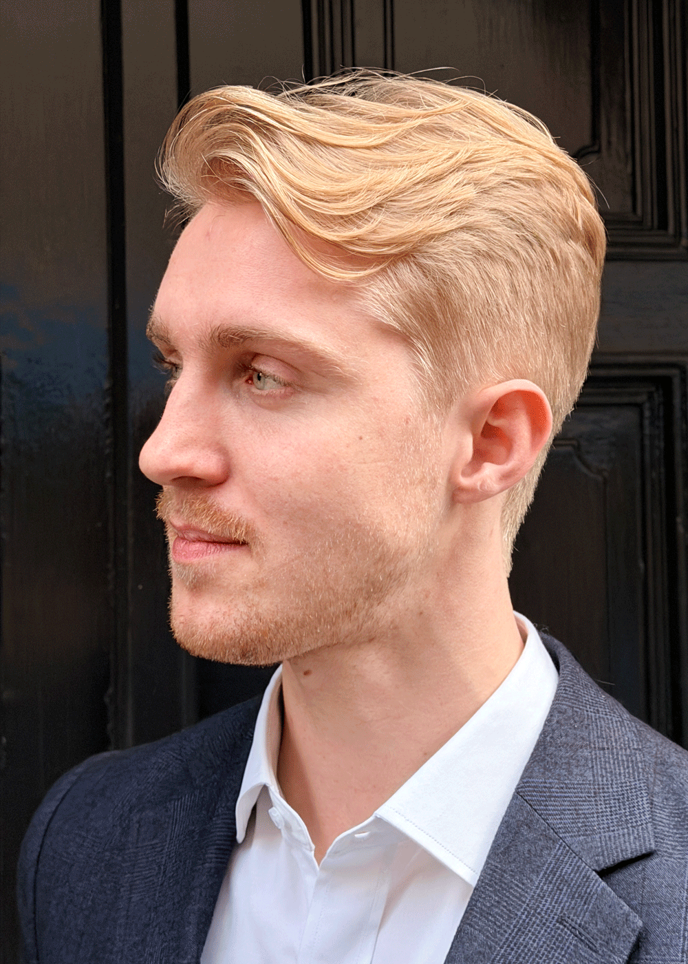 Low fade herrefrisyre med sideskille og formet volum i blondt hår