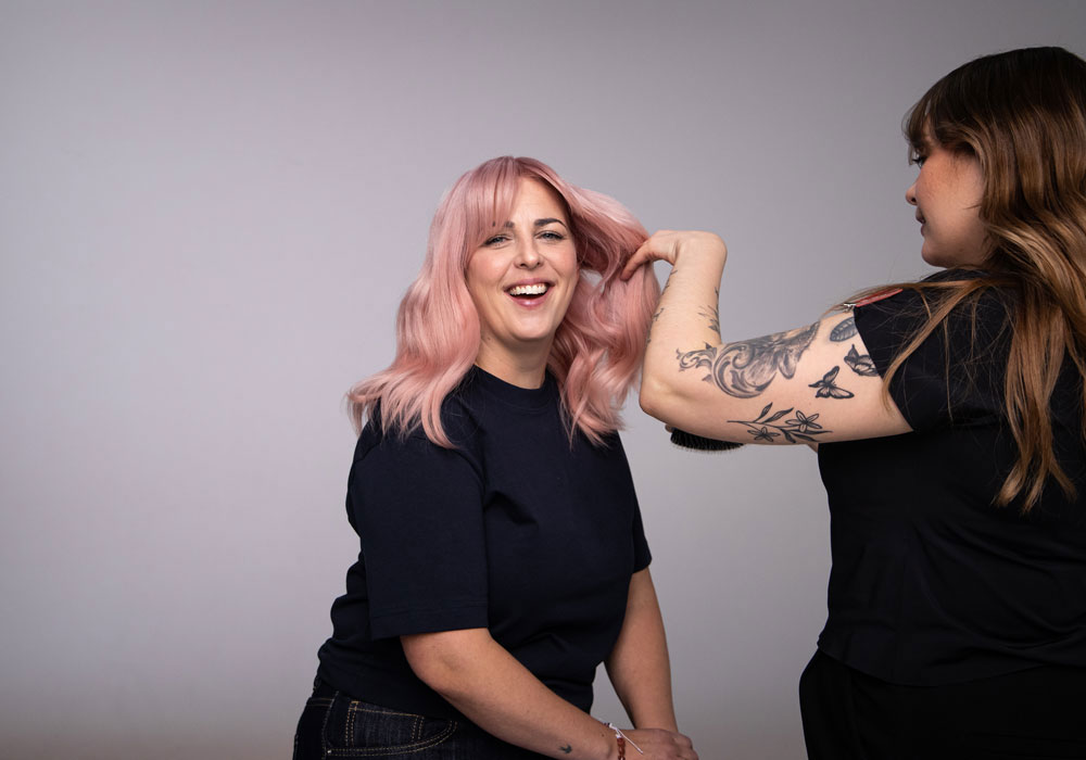 Styling av pudderrosa hår med myke lengder i salongmiljø
