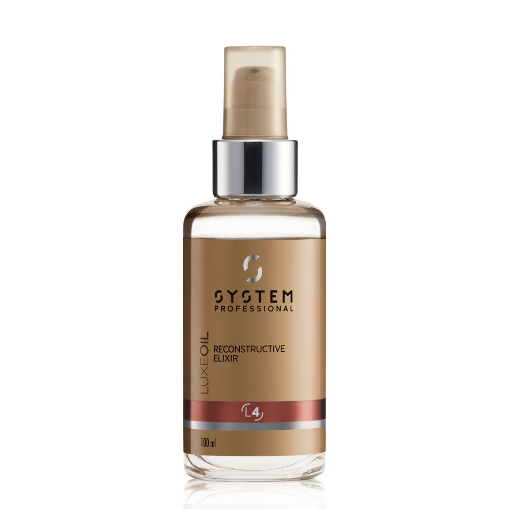 System Professional Luxe Oil Reconstructive Elixir hårolje i flaske holdt i hånden