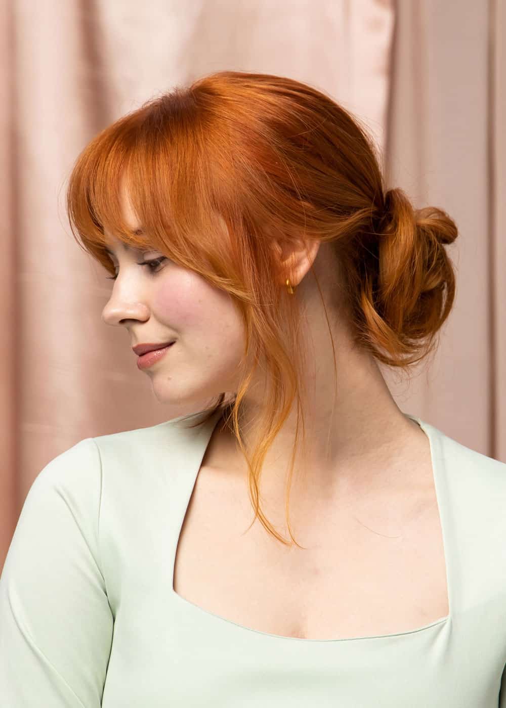 messy bun med lugg og løse lengder rundt ansiktet