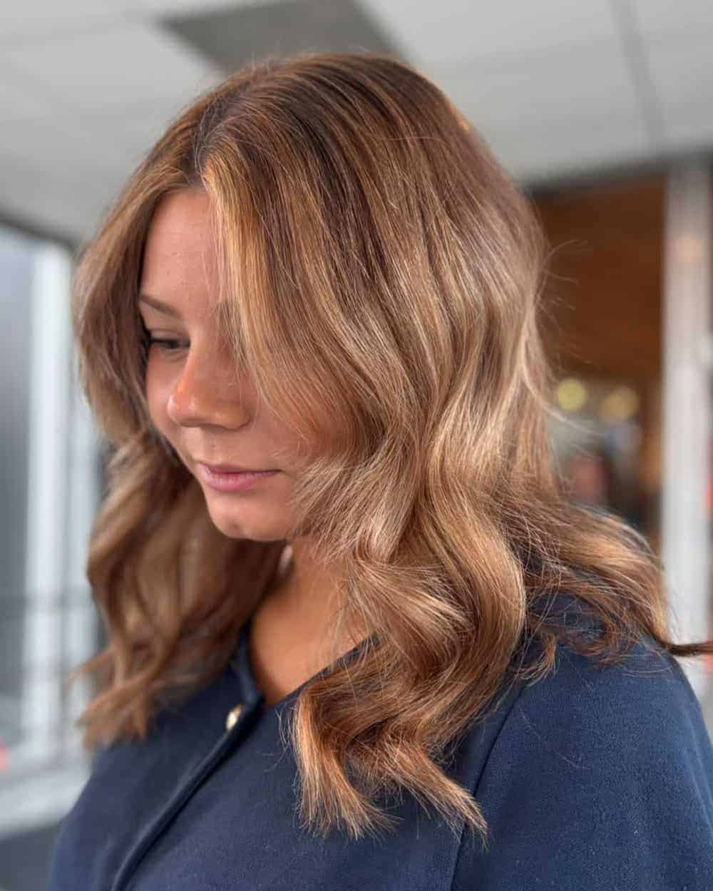 Bronde hårfarge med varme blonde og brune toner i bølget hår.