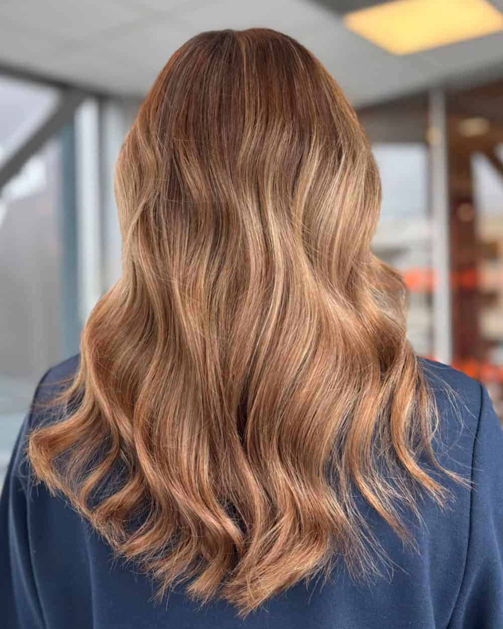 Bølget bronde hår med myke nyanser av karamell, honning og lysebrunt.