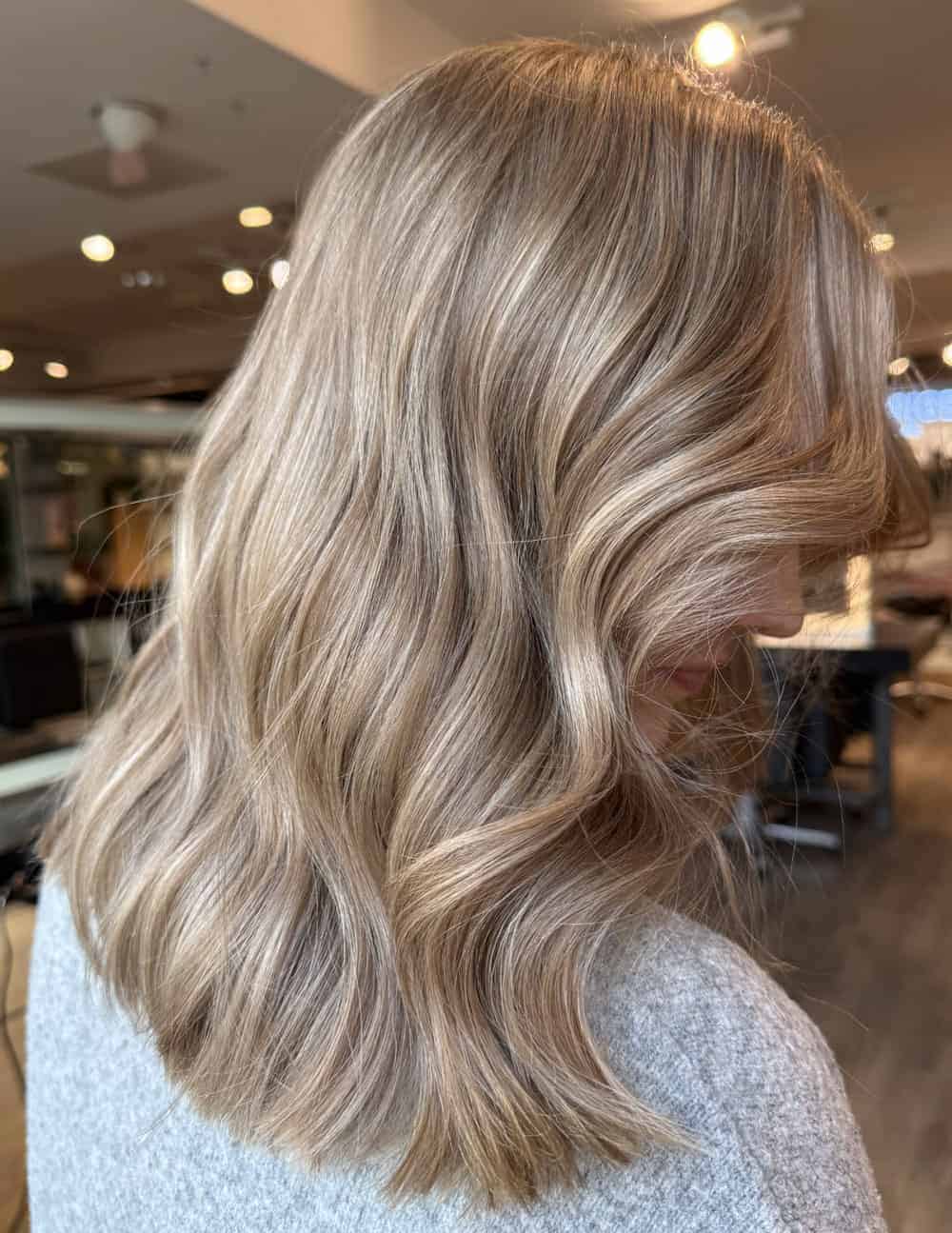 Champagneblondt hår med beige toner, myke bølger og naturlig glans.